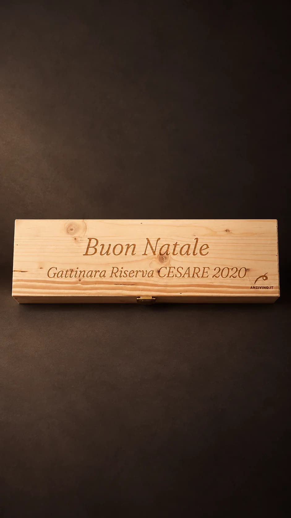 Caisse en pin d’une bouteille gravée en italique avec « Buon Natale », « Gattinara Riserva CESARE 2020 » et la marque Anzivino